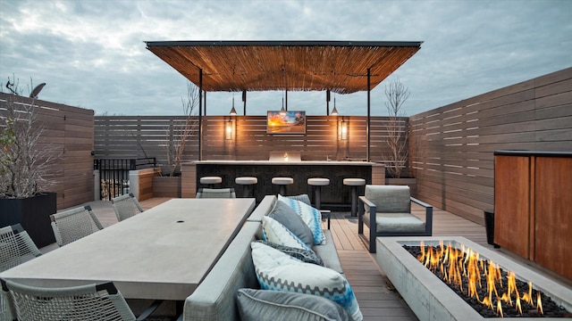 deck with a bar and an outdoor fire pit