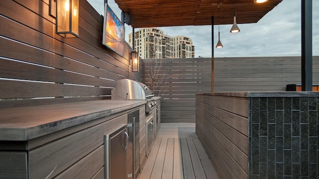 exterior space with an outdoor kitchen and a grill