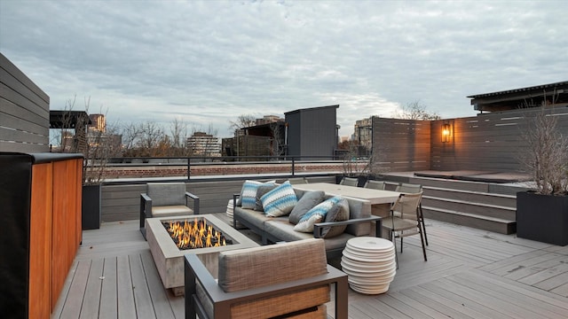 wooden terrace featuring an outdoor living space with a fire pit