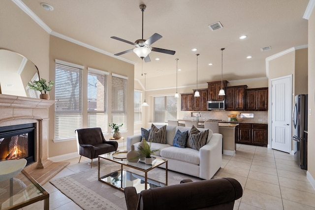 tiled living room featuring ceiling fan, plenty of natural light, and ornamental molding