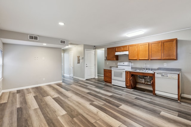 kitchen with hardwood / wood-style flooring, sink, and white appliances