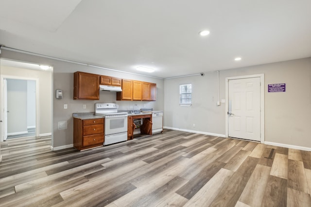 kitchen with white appliances and light hardwood / wood-style flooring