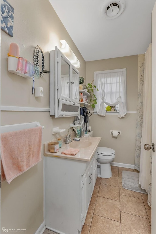 bathroom with toilet, tile patterned flooring, and vanity