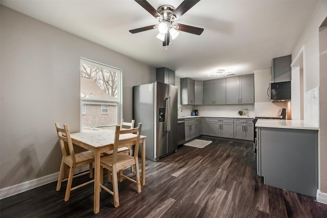 kitchen featuring high quality appliances, gray cabinets, dark hardwood / wood-style floors, and ceiling fan