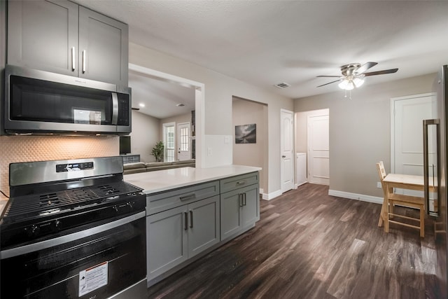 kitchen with dark hardwood / wood-style flooring, gray cabinetry, ceiling fan, and stainless steel appliances