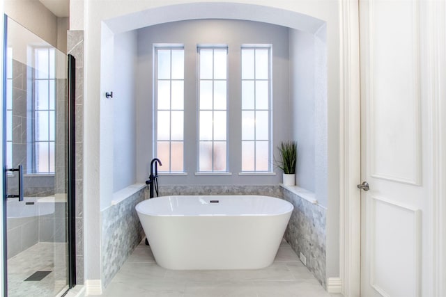 bathroom with separate shower and tub and tile walls