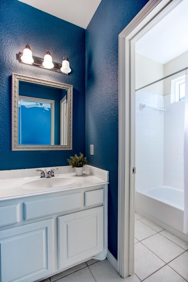 bathroom featuring tiled shower / bath, tile patterned floors, and vanity