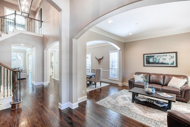 living room featuring ornamental molding, plenty of natural light, and dark wood-type flooring