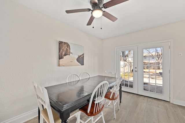 dining space with light hardwood / wood-style flooring, ceiling fan, and french doors