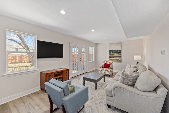 living room with light wood-type flooring and french doors