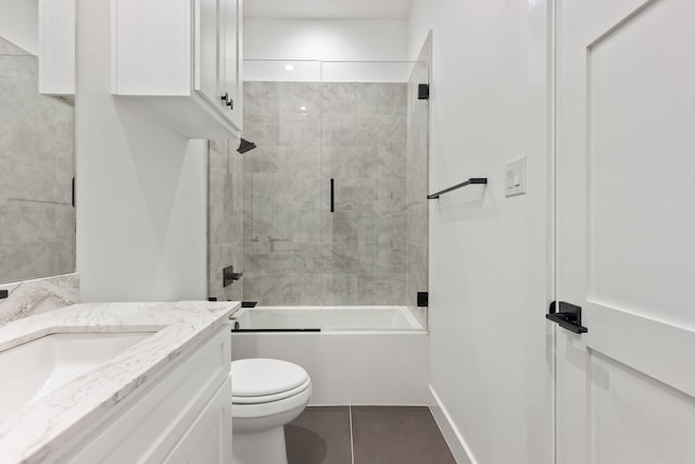 full bathroom featuring tile patterned floors, shower / bath combination with glass door, vanity, and toilet