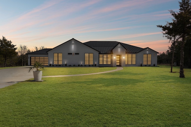 view of front of home featuring a garage and a lawn