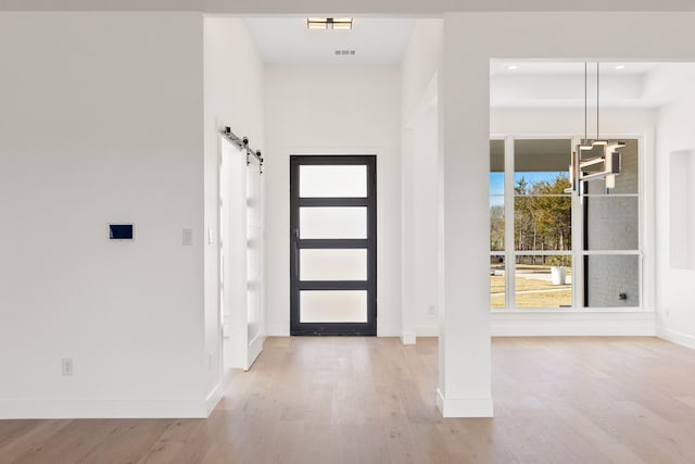 foyer featuring light wood-type flooring and a barn door