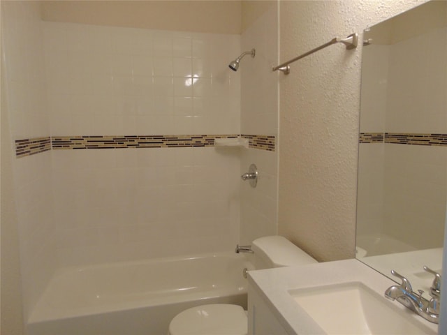 full bathroom with vanity, tiled shower / bath, and toilet