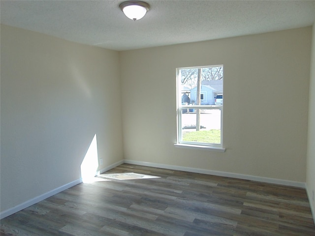 unfurnished room with dark hardwood / wood-style flooring and a textured ceiling