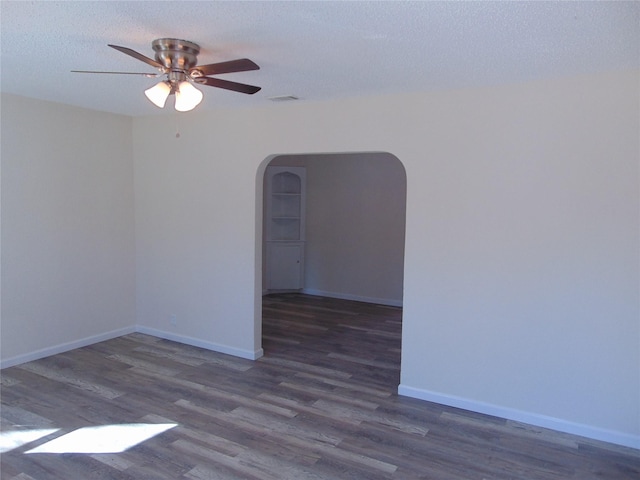 unfurnished room with ceiling fan, dark hardwood / wood-style floors, and a textured ceiling