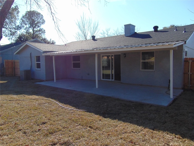 rear view of house with central AC, a lawn, and a patio