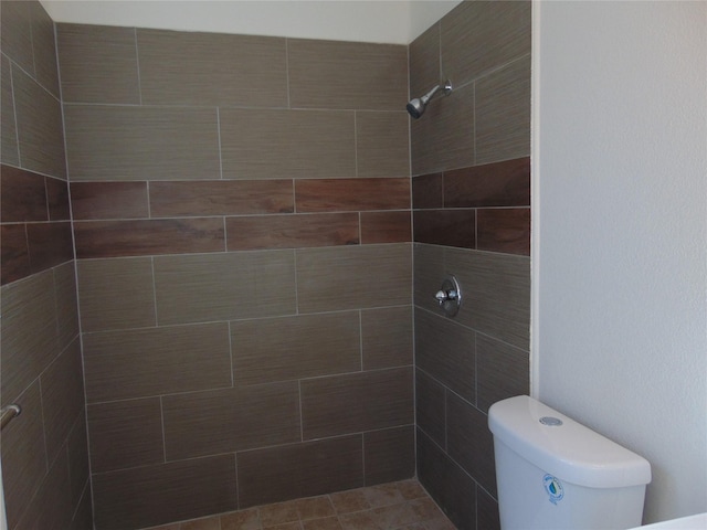 bathroom with toilet and a tile shower