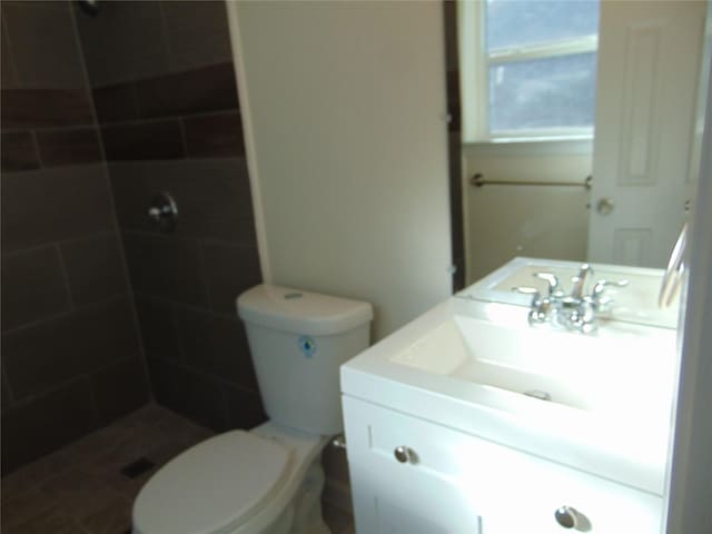 bathroom featuring toilet, walk in shower, and vanity