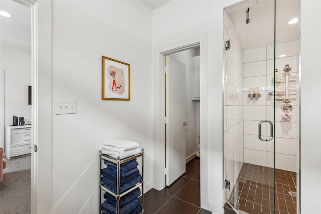 bathroom with a shower with shower door and tile patterned flooring