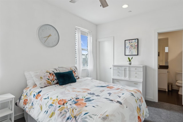 bedroom featuring dark carpet, connected bathroom, and ceiling fan