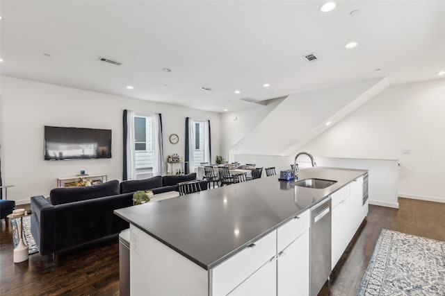 kitchen with white cabinetry, an island with sink, sink, dark hardwood / wood-style floors, and stainless steel dishwasher