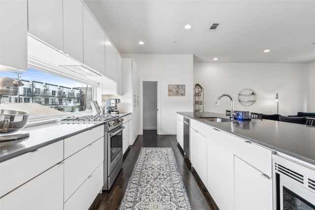 kitchen featuring sink, stainless steel appliances, white cabinets, and dark hardwood / wood-style flooring