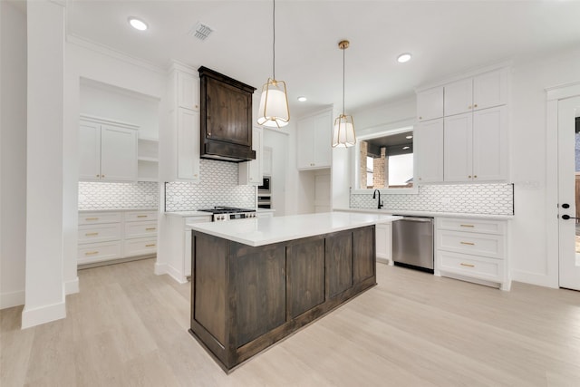 kitchen featuring stainless steel dishwasher, a center island, white cabinets, and light hardwood / wood-style floors