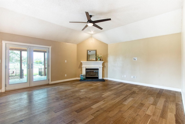 unfurnished living room with hardwood / wood-style flooring, vaulted ceiling, ceiling fan, and french doors