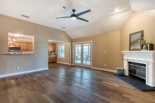 unfurnished living room featuring french doors, lofted ceiling, and dark hardwood / wood-style flooring