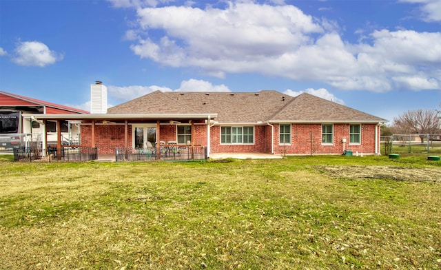 back of property with a patio and a yard