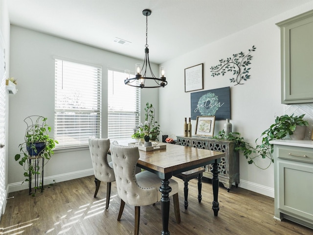 dining area featuring a chandelier and dark wood-type flooring