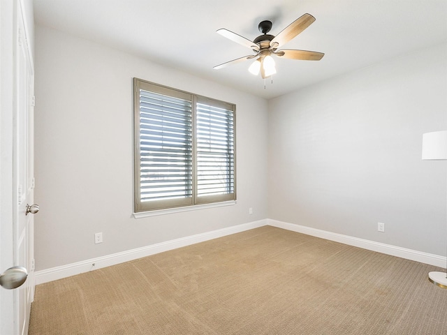 carpeted spare room with ceiling fan