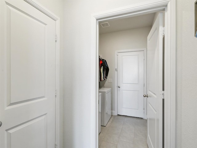 laundry room with washing machine and dryer and light tile patterned floors