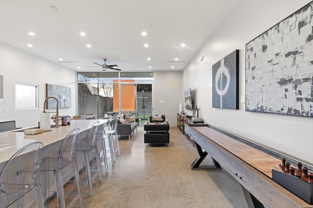 interior space featuring ceiling fan and a wall of windows