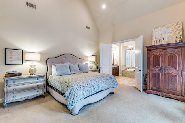 carpeted bedroom with high vaulted ceiling and ensuite bath