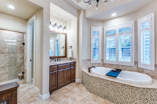 bathroom featuring vanity, an inviting chandelier, and separate shower and tub