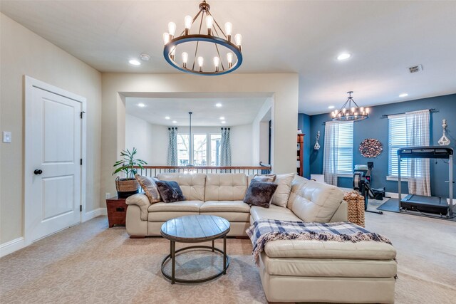 carpeted living room featuring a notable chandelier