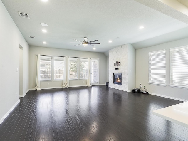 unfurnished living room featuring ceiling fan, a textured ceiling, dark hardwood / wood-style floors, and a fireplace