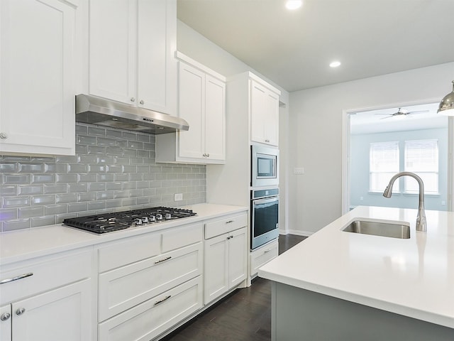 kitchen with white cabinets, stainless steel appliances, sink, dark hardwood / wood-style floors, and ceiling fan