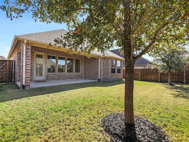 back of property with a patio area and a lawn