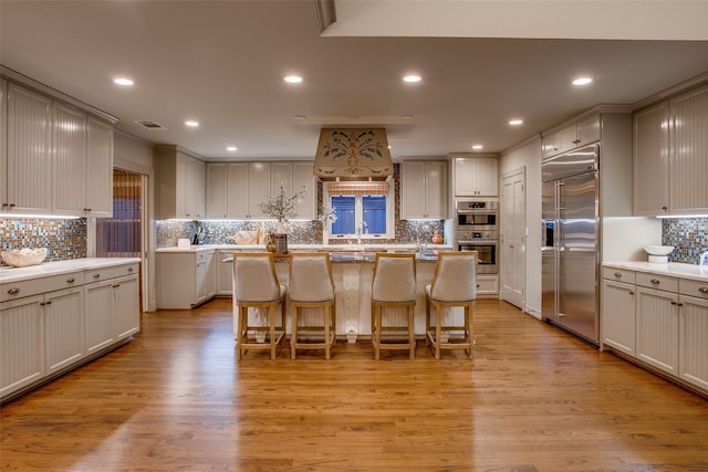 kitchen featuring a center island, a kitchen breakfast bar, light hardwood / wood-style flooring, and stainless steel appliances