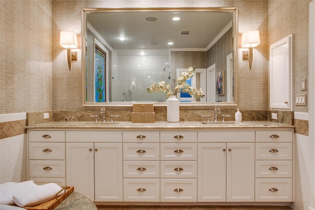 bathroom featuring a shower with door, vanity, and ornamental molding