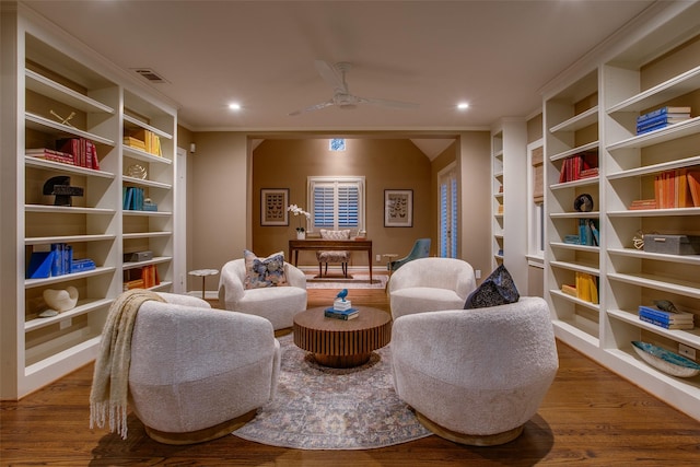 sitting room with built in features, ceiling fan, and hardwood / wood-style floors