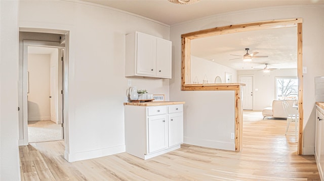 kitchen with white cabinets, light wood-type flooring, and ceiling fan