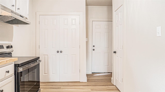 kitchen with white cabinets, light hardwood / wood-style flooring, and stainless steel electric range oven