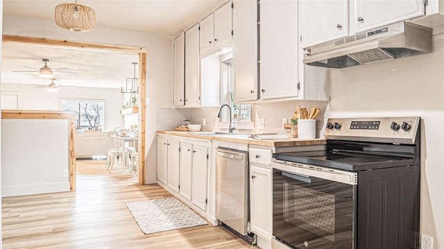 kitchen with appliances with stainless steel finishes, tasteful backsplash, hanging light fixtures, white cabinets, and sink