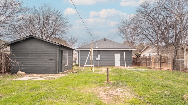 back of property featuring a lawn and a storage unit