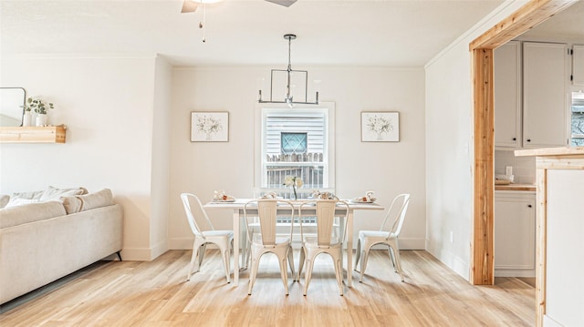 dining room featuring crown molding, light hardwood / wood-style floors, and ceiling fan