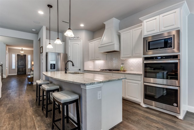 kitchen featuring light stone countertops, white cabinets, appliances with stainless steel finishes, and sink